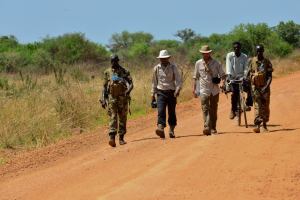 Lev and Boston walk with SPLA officers and a porter on the road North from Juba heading towards Terekeka.  (Tom McShane Photography)